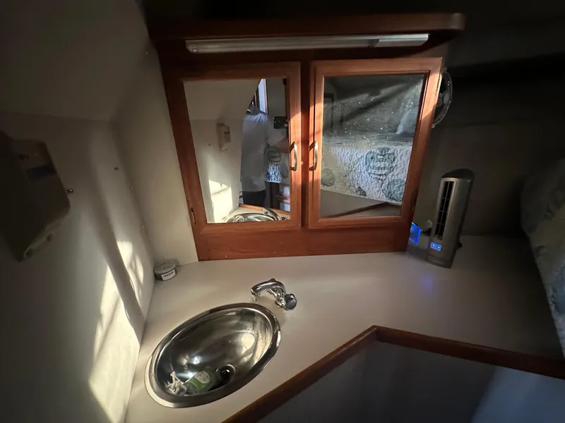Slide: The Image of 1988 Carver 280 Voyager cabin interior with sink, mirror, and wooden cabinetry. - 18