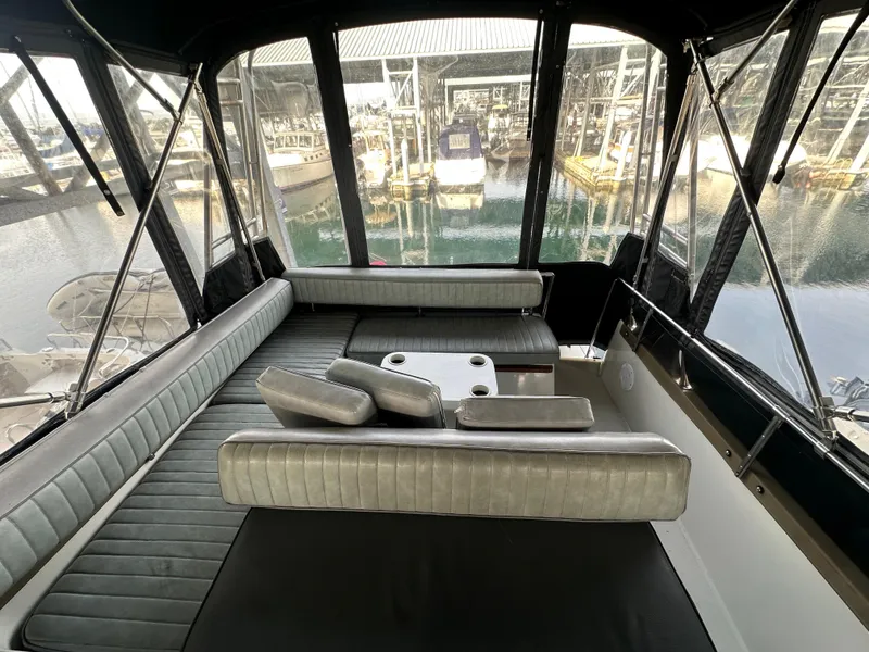 Slide: The Image of Interior of 1988 Carver 280 Voyager boat with seating and marina view. - 9