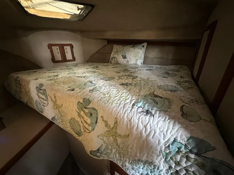 Slide: The Image of Cozy cabin bed in 1988 Carver 280 Voyager with nautical-themed bedding. - 17