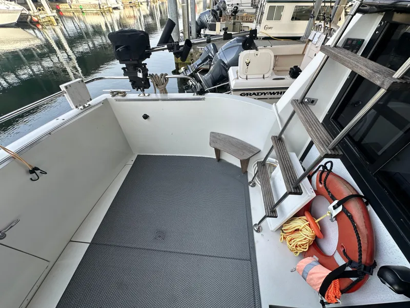 Slide: The Image of 1988 Carver 280 Voyager boat deck with safety equipment and docked boats in background. - 19