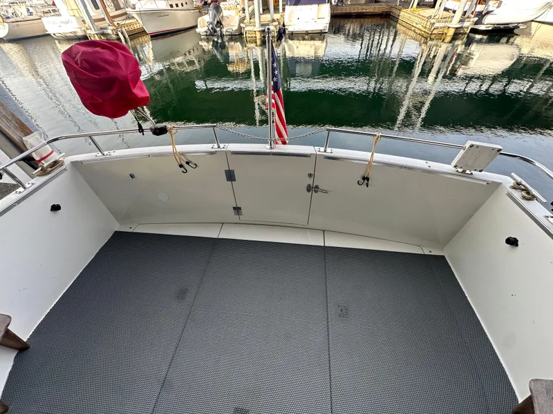 Slide: The Image of 1988 Carver 280 Voyager boat deck with marina view, featuring clean flooring and railing. - 20