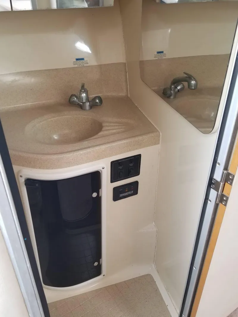 Slide: The Image of 2000 Wellcraft 3000 Martinique bathroom with sink, faucet, and storage cabinet. - 10