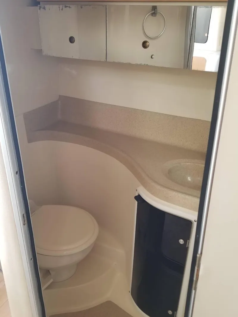 Slide: The Image of Compact bathroom in 2000 Wellcraft 3000 Martinique boat, featuring toilet and sink. - 11