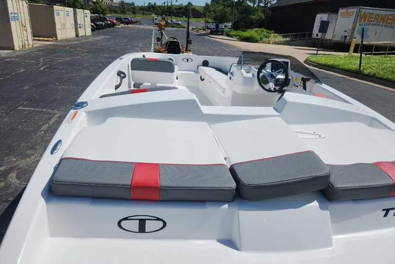 Slide: The Image of 2025 Tahoe T18 boat with gray and red seating, docked outdoors. - 2