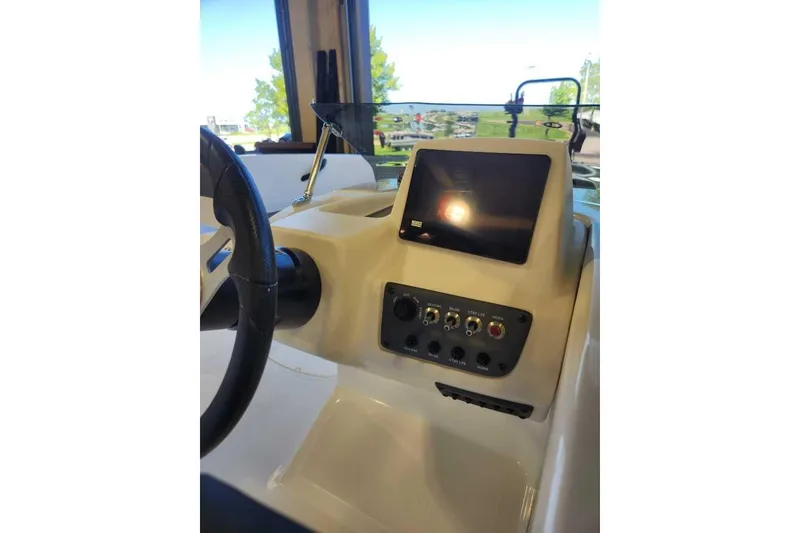 Slide: The Image of 2025 Tahoe T18 boat dashboard with steering wheel and control panel. - 69