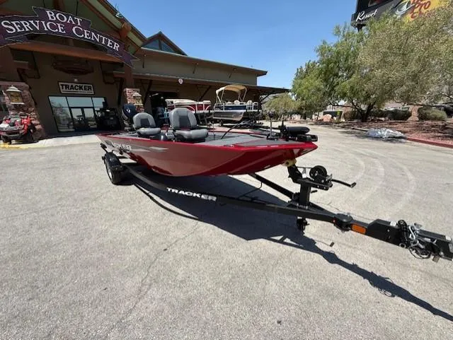Slide: The Image of 2025 Tracker Panfish 17 boat at service center, red color, on trailer. - 2