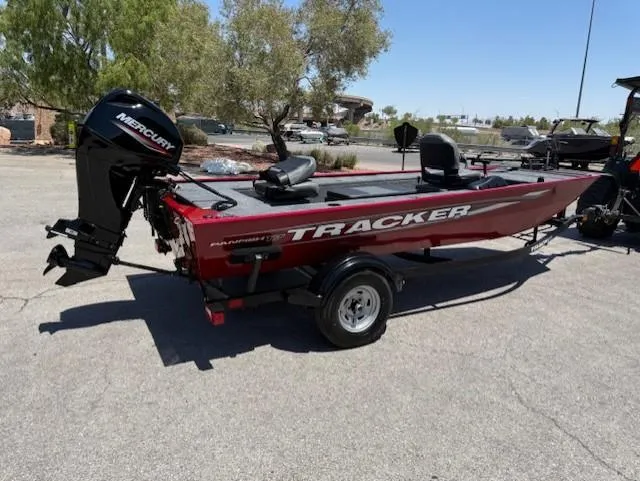 Slide: The Image of 2025 Tracker Panfish 17 boat with Mercury engine, parked outdoors on a sunny day. - 5