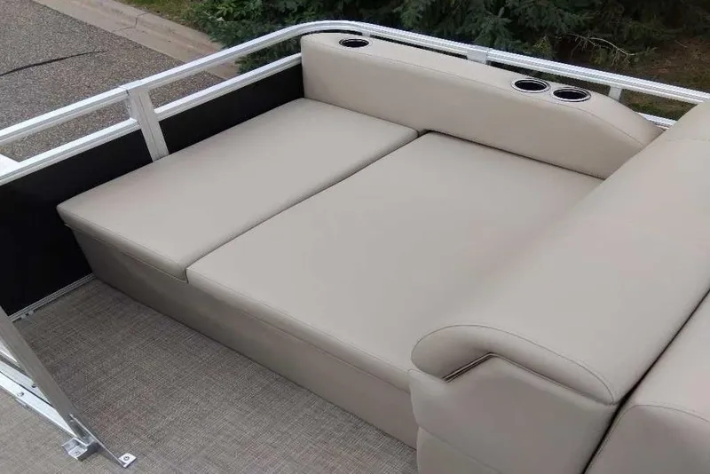 Slide: The Image of 2025 Sun Tracker Sportfish 24 XP3 boat seating with beige upholstery and cup holders. - 5