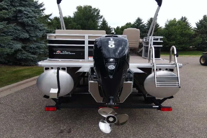 Slide: The Image of 2025 Sun Tracker Sportfish 24 XP3 pontoon boat with powerful outboard motor, parked outdoors. - 6