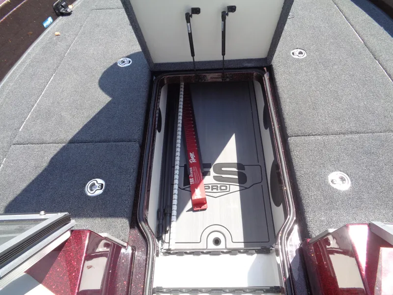 Slide: The Image of 2022 Ranger 621 FS PRO boat storage compartment with measuring ruler and carpeted deck. - 6