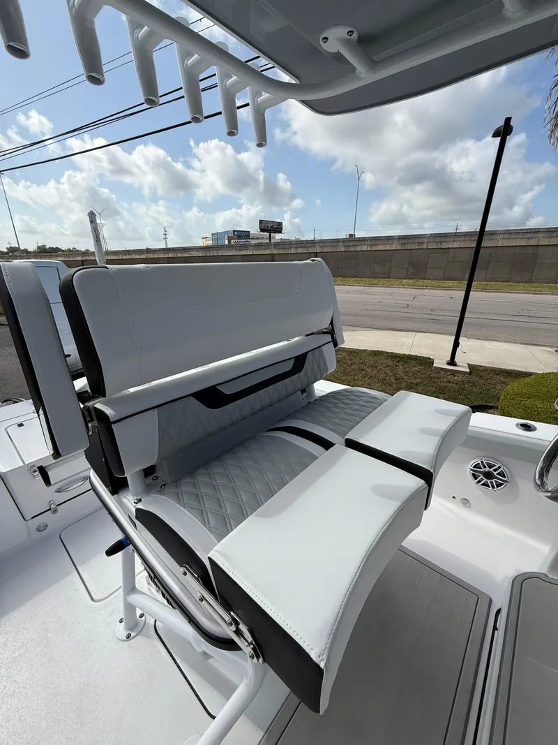 Slide: The Image of 2026 Blackfin 262 HB boat seating with rod holders, under a partly cloudy sky. - 14