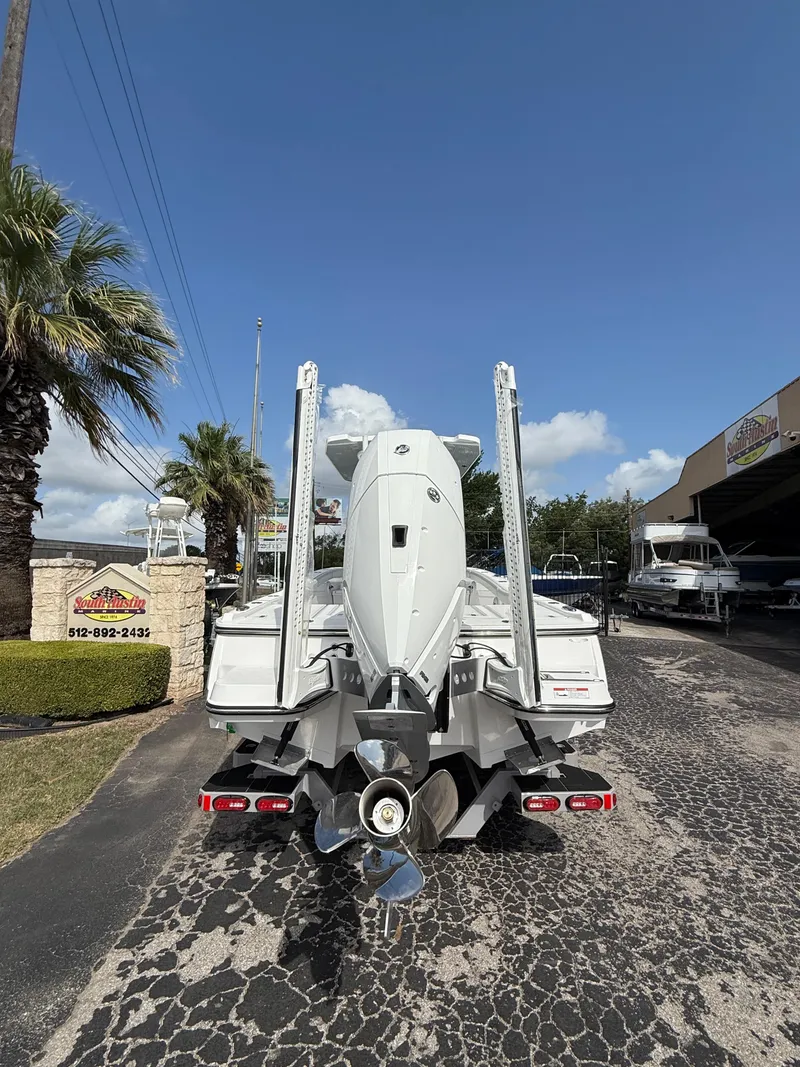 Slide: The Image of 2026 Blackfin 262 HB boat rear view, parked outdoors under a clear blue sky. - 4