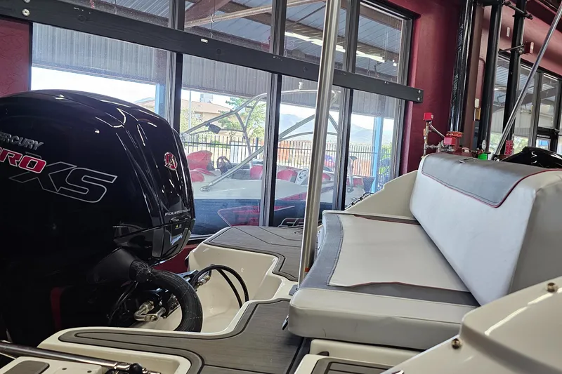 Slide: The Image of 2023 Bayliner Element M19 boat interior with Mercury Pro XS engine, displayed indoors. - 2