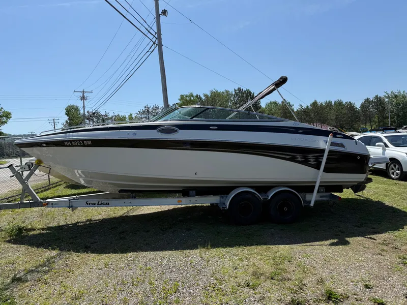 The Image of 2007 Crownline 270 BR boat on trailer, parked outdoors under clear sky. - 0