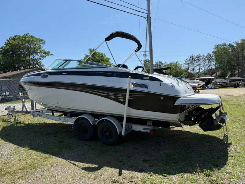 Slide: The Image of 2007 Crownline 270 BR boat on trailer, parked outdoors under clear sky. - 12