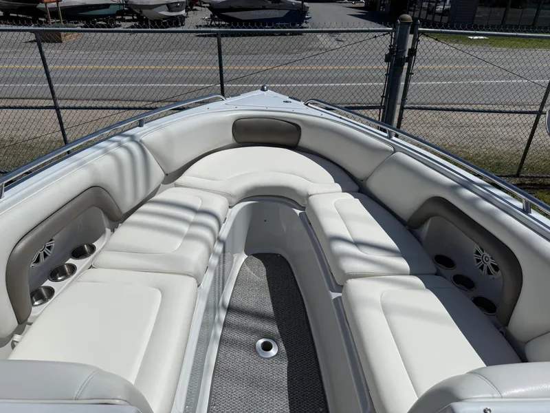 Slide: The Image of 2007 Crownline 270 BR boat interior with white cushioned seating and cup holders. - 6