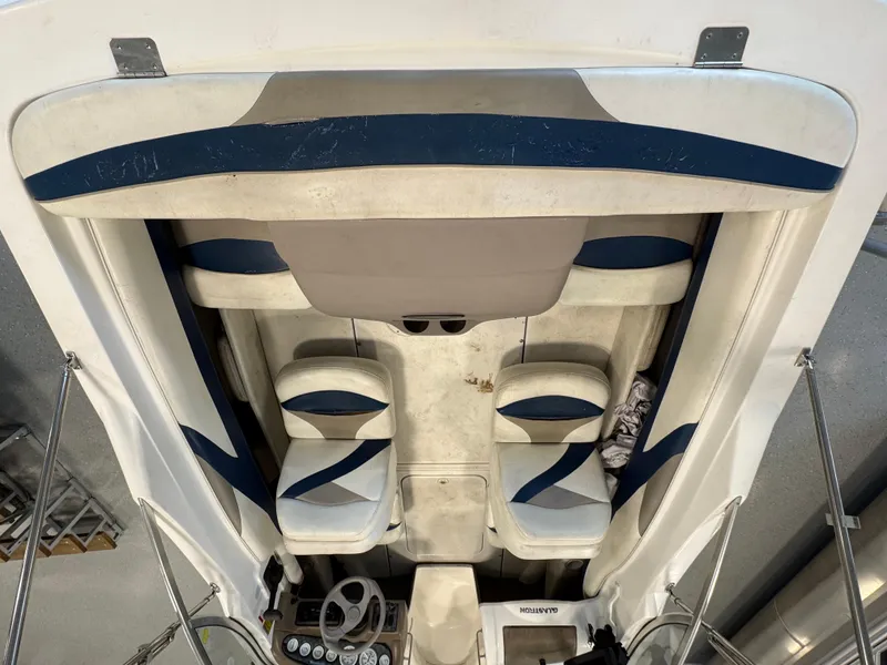 Slide: The Image of Interior view of a 2001 Glastron SX175 boat, featuring white and blue seating. - 6