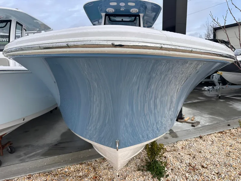Slide: The Image of 2025 Sportsman Heritage 231 Center Console boat, blue hull, parked on gravel. - 13