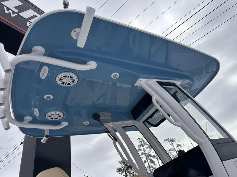 Slide: The Image of 2025 Sportsman Heritage 231 Center Console boat, featuring a blue T-top with integrated speakers. - 14