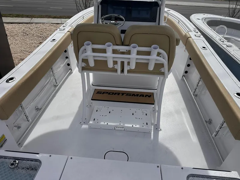 Slide: The Image of 2025 Sportsman Heritage 231 Center Console boat interior with beige seating and rod holders. - 15