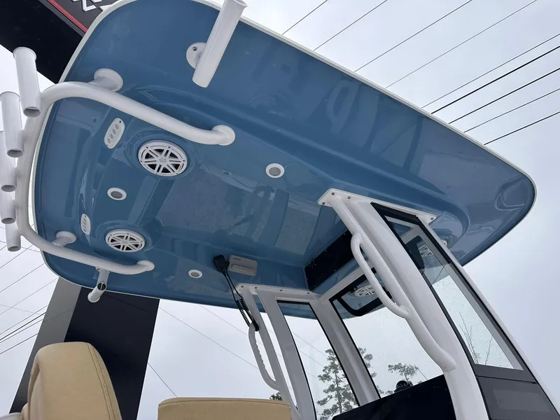 Slide: The Image of 2025 Sportsman Heritage 231 Center Console boat with blue T-top and speakers. - 2