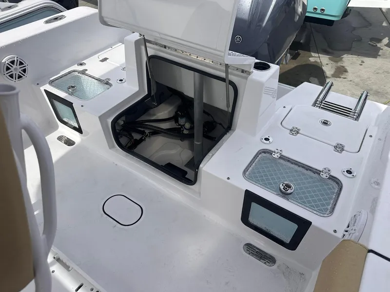 Slide: The Image of 2025 Sportsman Heritage 231 Center Console boat interior with storage compartments and ladder. - 23