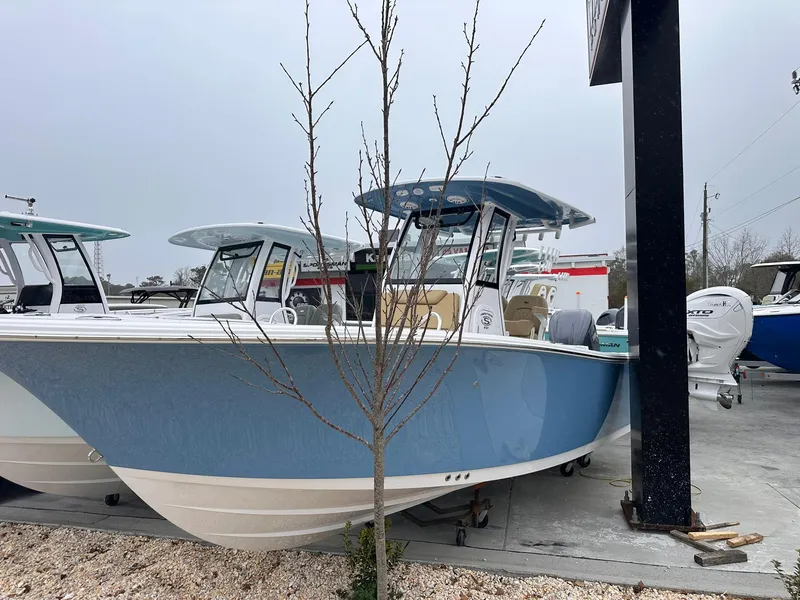 Slide: The Image of 2025 Sportsman Heritage 231 Center Console boat in a showroom, featuring a sleek blue design. - 3