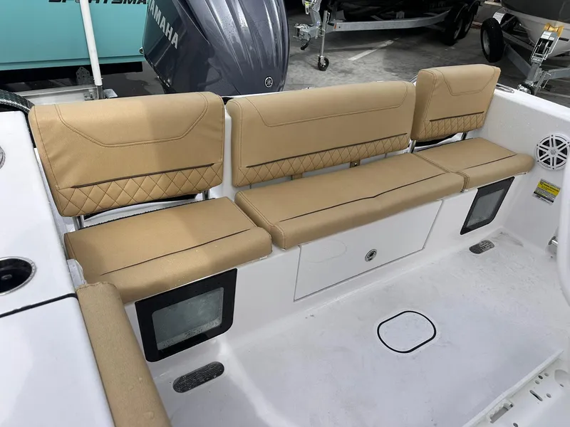 Slide: The Image of 2025 Sportsman Heritage 231 Center Console boat with tan cushioned seating and storage compartments. - 30