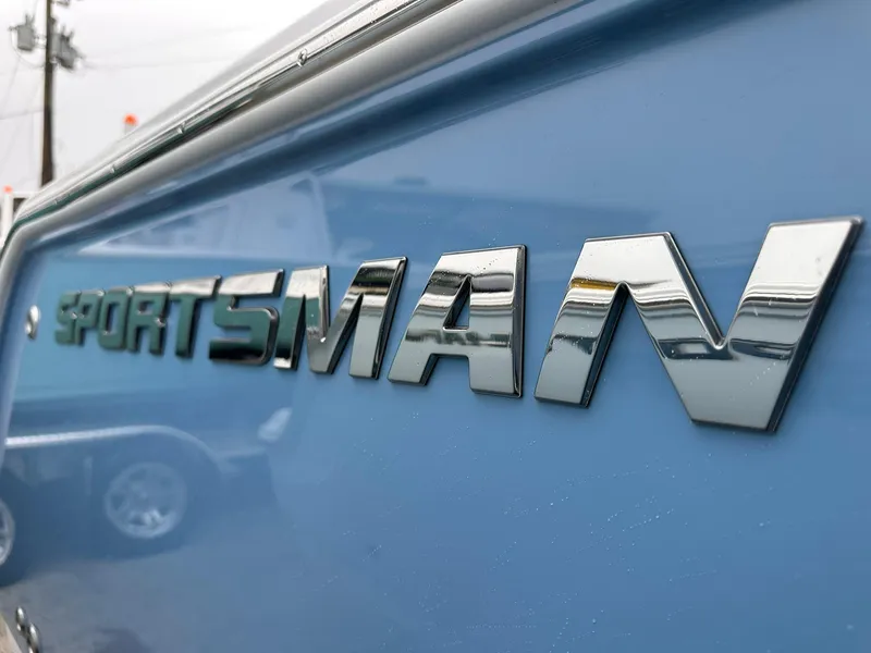 Slide: The Image of 2025 Sportsman Heritage 231 Center Console boat logo on blue surface. - 4