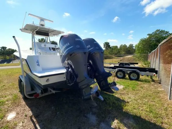Slide: The Image of 1999 Contender 28 Sport boat with dual Yamaha engines on a trailer, parked outdoors. - 16