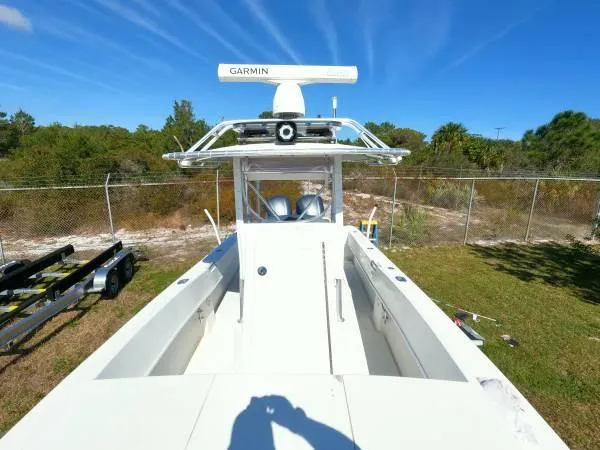 Slide: The Image of 1999 Contender 28 Sport boat with Garmin radar, parked on grass near a fence. - 7