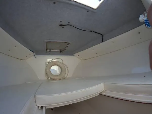 Slide: The Image of Interior cabin of a 1999 Contender 28 Sport boat, featuring cushioned seating. - 8
