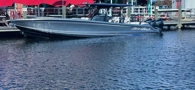 Slide: The Image of 2023 Nor-Tech 390 Sport Center Console boat docked by waterfront restaurant. - 19