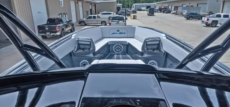Slide: The Image of 2023 Nor-Tech 390 Sport Center Console boat in a marina with parked vehicles. - 8