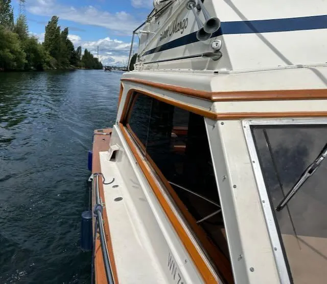 Slide: The Image of 1978 Egg Harbor 36 Sedan cruising on a scenic waterway under a partly cloudy sky. - 15