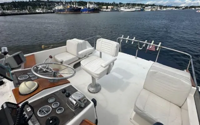 Slide: The Image of 1978 Egg Harbor 36 Sedan boat deck with steering wheel, white seating, and waterfront view. - 38