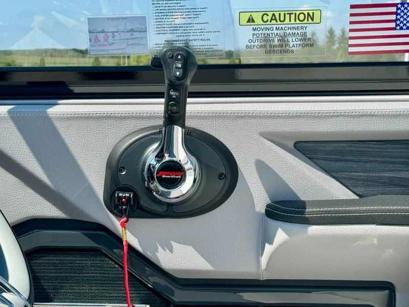 Slide: The Image of Throttle control panel of 2022 Cobalt A29 boat with caution label and American flag sticker. - 24