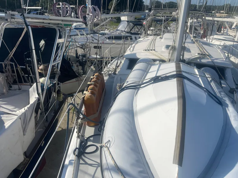 Slide: The Image of Hunter 44 DS Deck Salon 2004 sailboat on land, with American flag and nearby vehicles. - 17