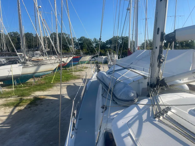 Slide: The Image of 2004 Hunter 44 DS Deck Salon sailboat with mounted life raft in marina. - 38