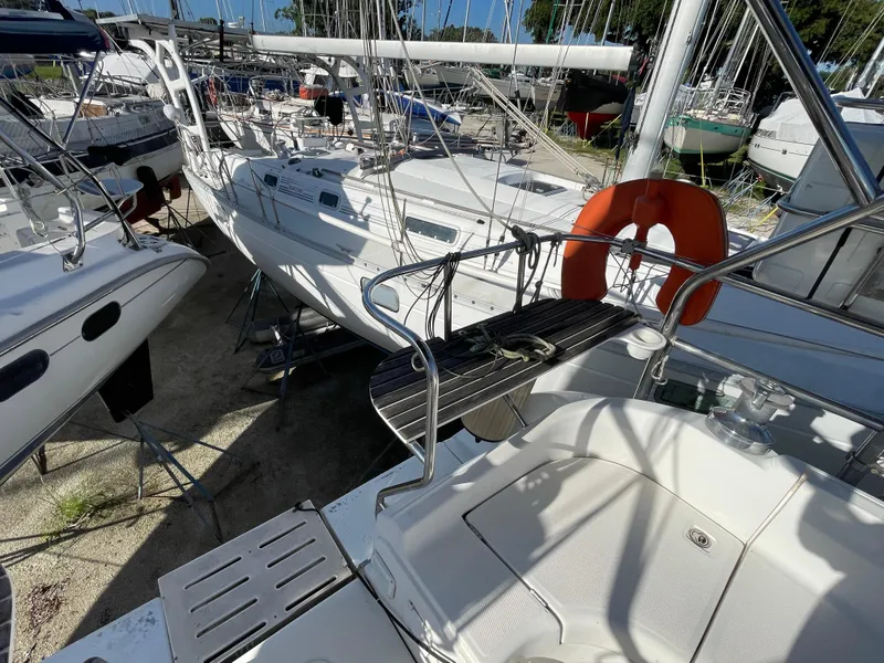 Slide: The Image of Hunter 44 DS Deck Salon 2004 sailboat docked among other vessels in a marina. - 43