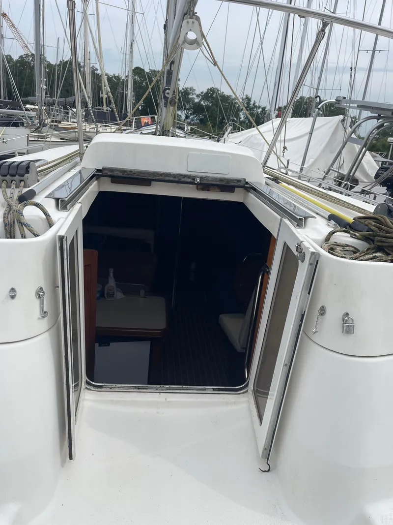 Slide: The Image of Interior of 2004 Hunter 44 DS Deck Salon with wood paneling and seating area. - 7