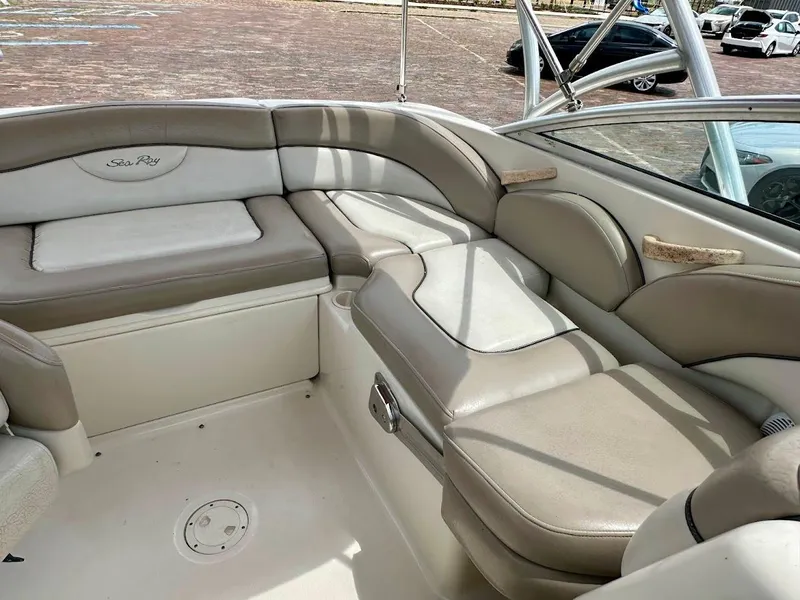 Slide: The Image of 2004 Sea Ray SunDeck 200 interior with beige seating and stainless steel accents. - 18