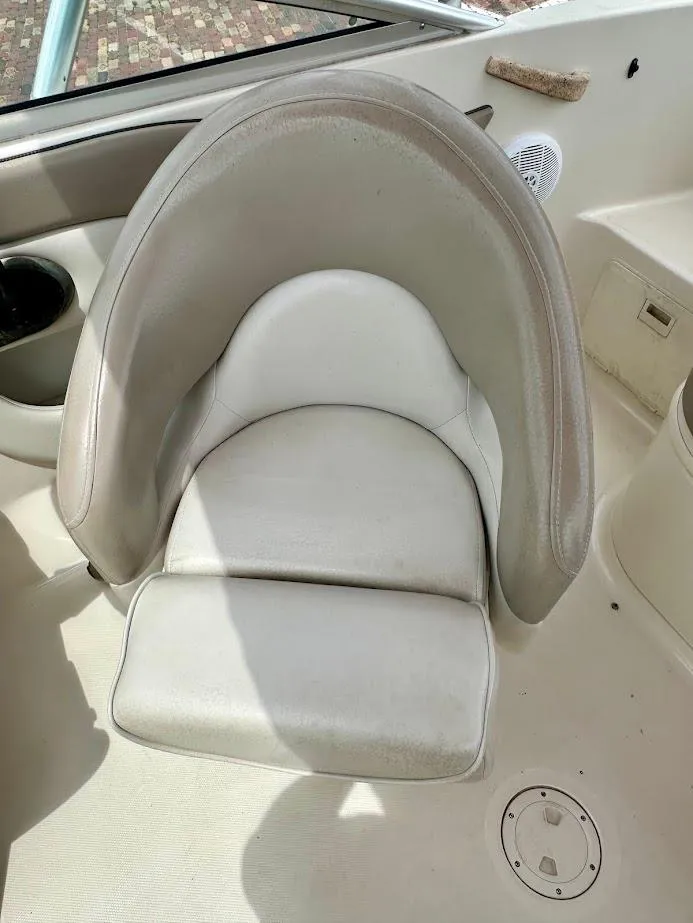 Slide: The Image of 2004 Sea Ray SunDeck 200 boat seat, white and gray upholstery, cup holder nearby. - 20