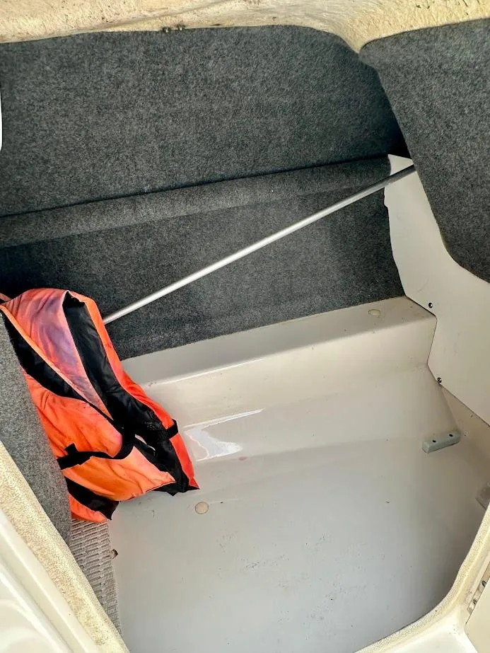 Slide: The Image of Storage compartment of a 2004 Sea Ray SunDeck 200 with life jacket inside. - 23
