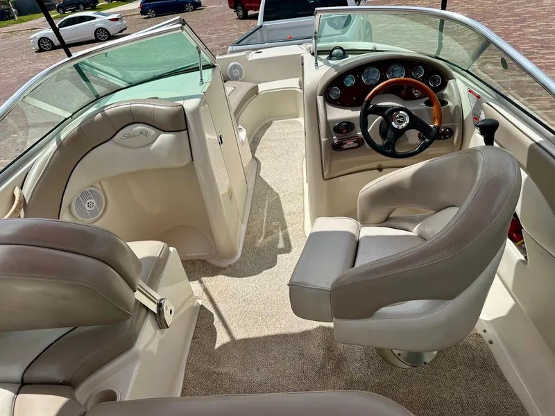 Slide: The Image of 2004 Sea Ray SunDeck 200 interior with beige seating and steering wheel. - 27
