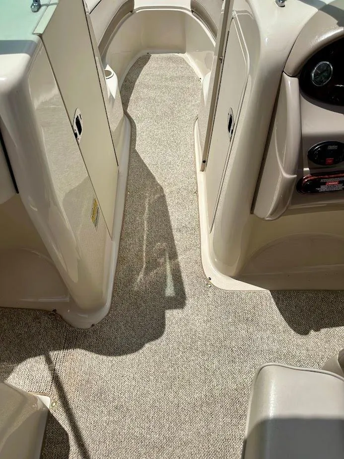 Slide: The Image of 2004 Sea Ray SunDeck 200 interior with beige carpet and dashboard view. - 28