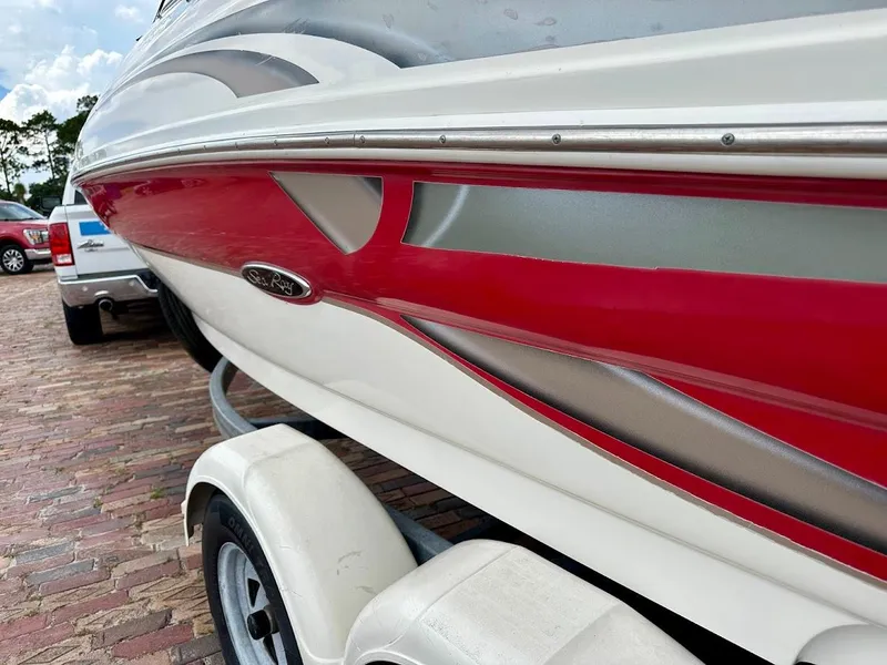 Slide: The Image of 2004 Sea Ray SunDeck 200 boat on trailer, featuring red and white design. - 3
