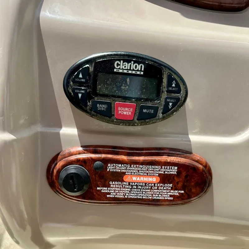 Slide: The Image of 2004 Sea Ray SunDeck 200 dashboard with Clarion Marine audio system and safety warning label. - 31