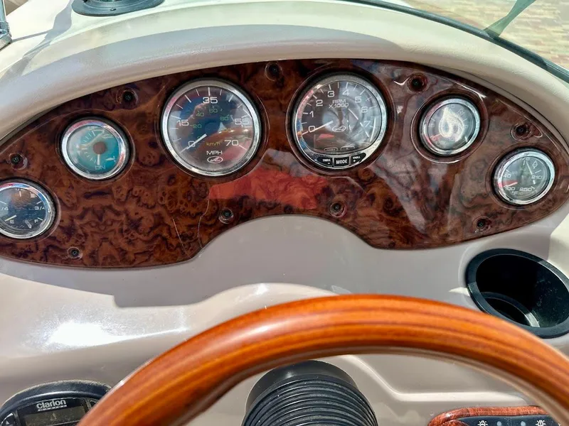 Slide: The Image of Dashboard of a 2004 Sea Ray SunDeck 200 boat with wood finish and gauges. - 32