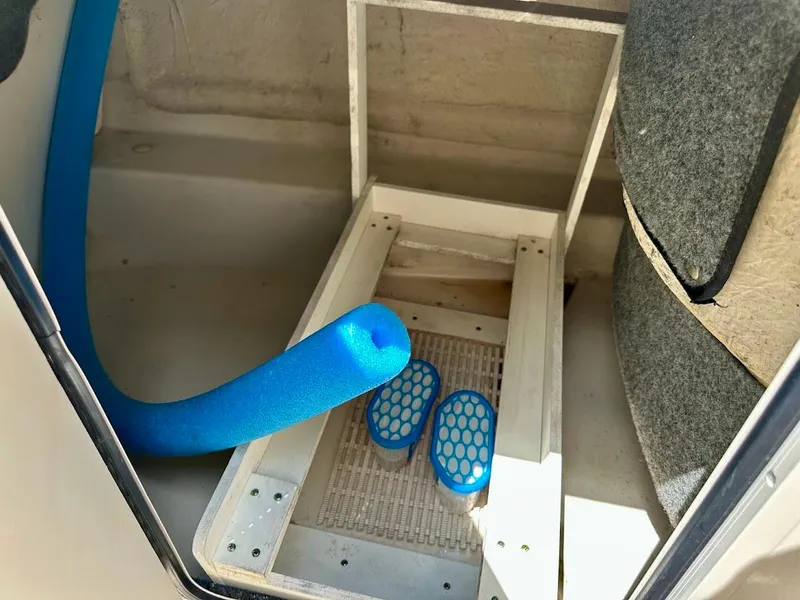 Slide: The Image of Interior of 2004 Sea Ray SunDeck 200 boat with blue pool noodle and accessories. - 34
